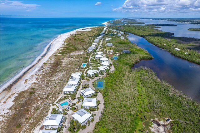 birds eye view of property with a water view and a beach view