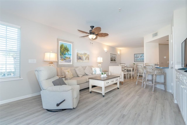 living room with ceiling fan and light hardwood / wood-style floors