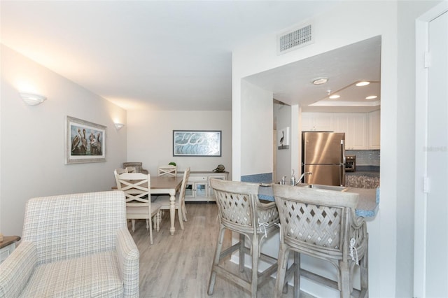 dining space with light hardwood / wood-style floors