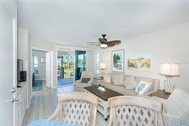 living room with light hardwood / wood-style flooring and ceiling fan