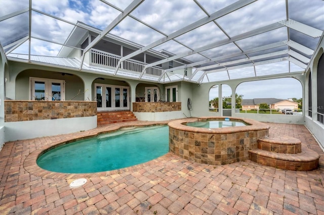 view of swimming pool featuring french doors, a patio area, glass enclosure, and an in ground hot tub