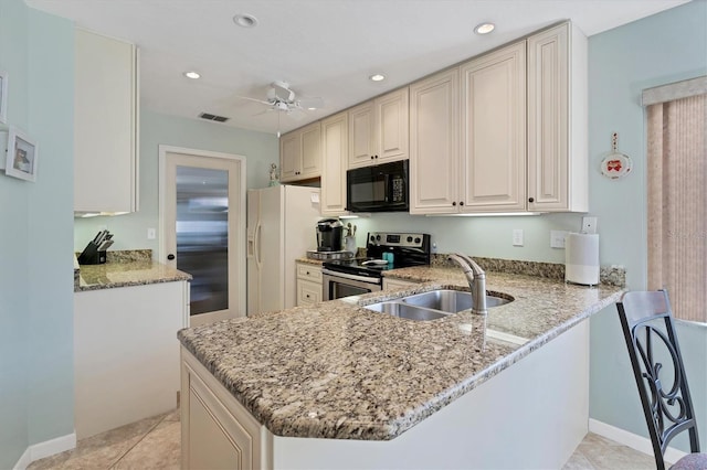 kitchen featuring stainless steel range with electric cooktop, kitchen peninsula, ceiling fan, sink, and light stone countertops