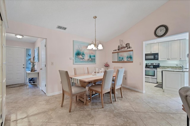 dining space featuring lofted ceiling, light tile floors, sink, and an inviting chandelier