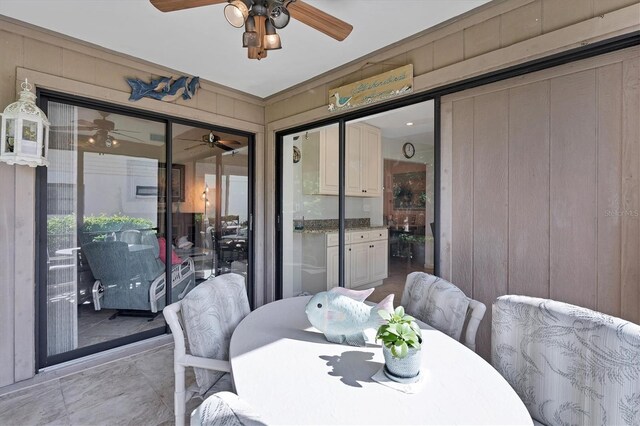 dining area featuring wood walls and ceiling fan