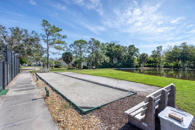 view of property's community with a water view and a yard