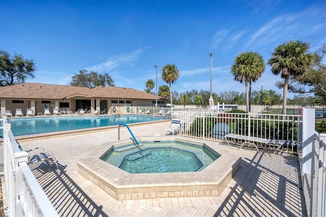 view of swimming pool with a patio and a hot tub