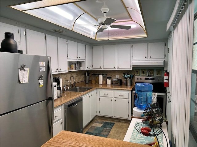 kitchen with stainless steel appliances, sink, white cabinets, and backsplash