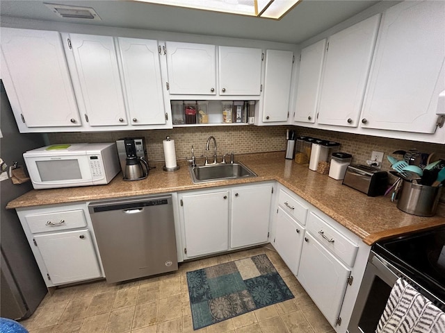 kitchen featuring white cabinetry, sink, backsplash, and appliances with stainless steel finishes