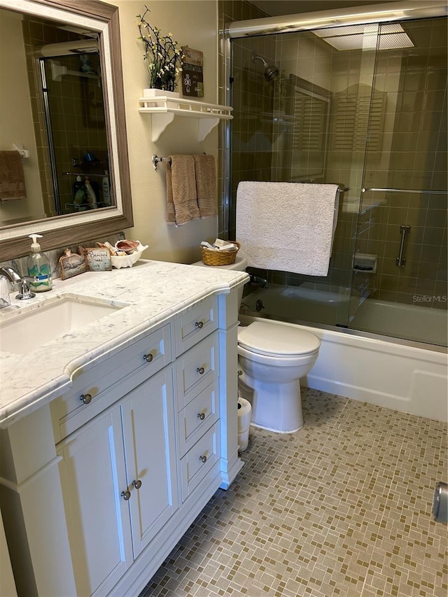 full bathroom featuring vanity, shower / bath combination with glass door, and toilet