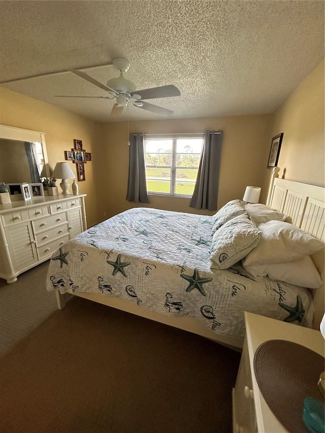 carpeted bedroom featuring ceiling fan and a textured ceiling