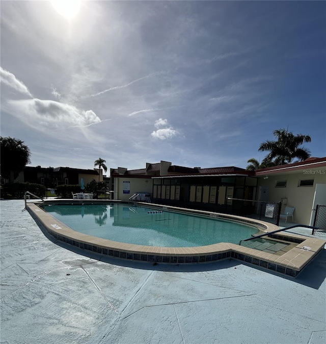 view of swimming pool with a hot tub and a patio