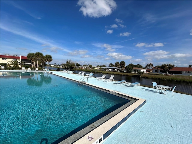 view of pool featuring a patio area and a water view