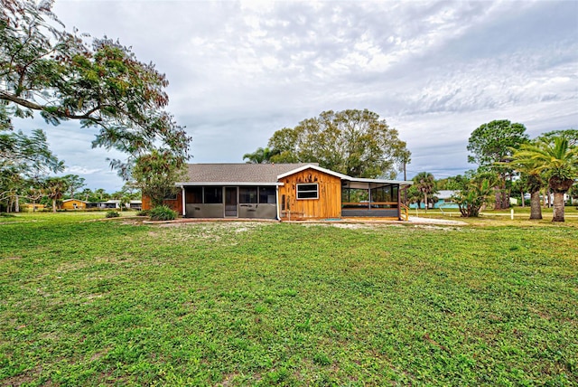 rear view of property featuring a lawn