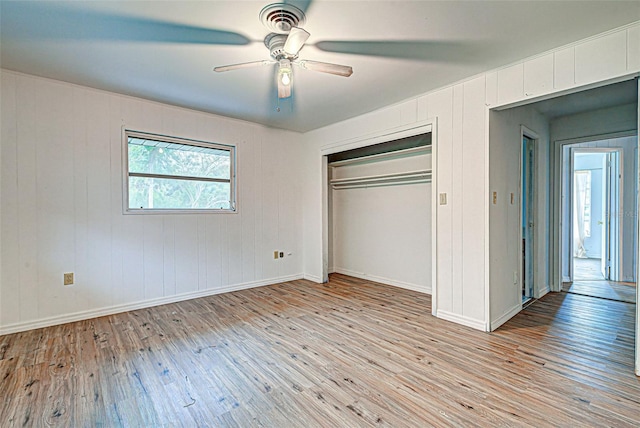 unfurnished bedroom featuring ceiling fan, a closet, and light hardwood / wood-style flooring