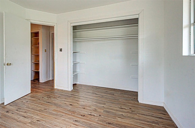 unfurnished bedroom featuring a closet and dark hardwood / wood-style flooring