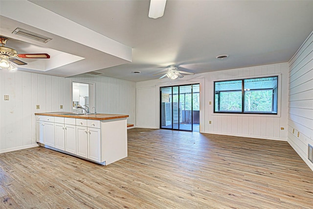 kitchen with white cabinets, light hardwood / wood-style floors, and ceiling fan