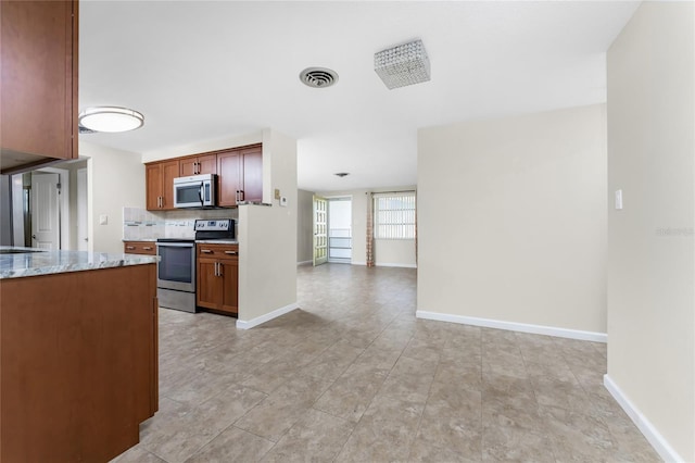 kitchen with appliances with stainless steel finishes, tasteful backsplash, light tile floors, and light stone counters