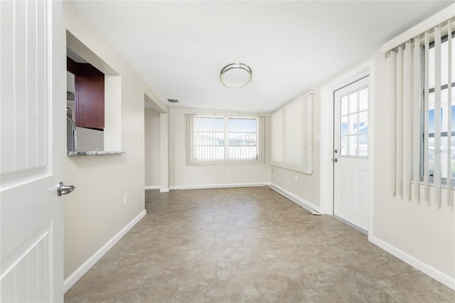 tiled spare room featuring plenty of natural light