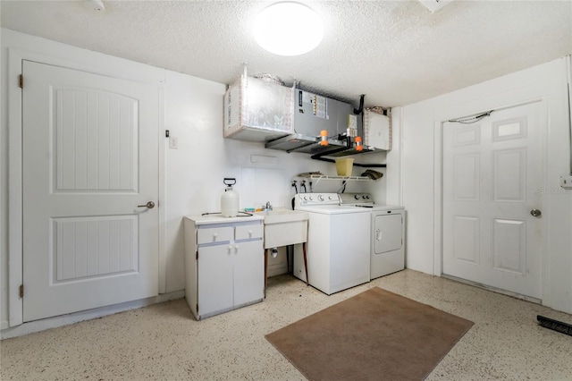 clothes washing area featuring washer and dryer, sink, and a textured ceiling