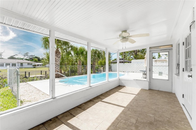 unfurnished sunroom with ceiling fan