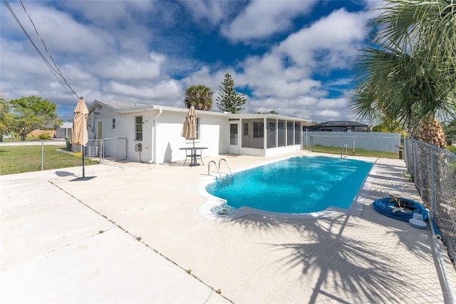 view of swimming pool featuring a patio area and a sunroom