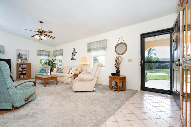 tiled living room with lofted ceiling, ceiling fan, and a healthy amount of sunlight