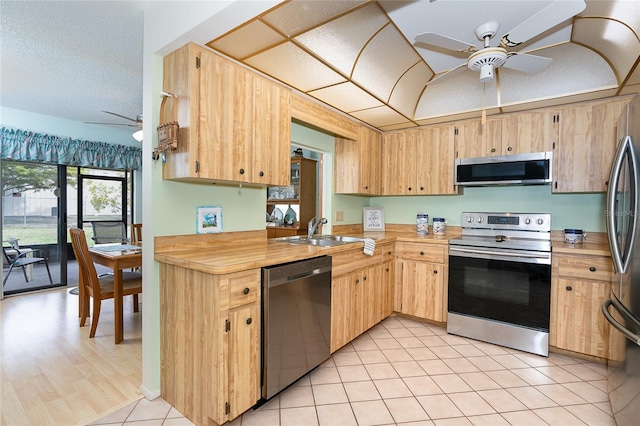 kitchen with ceiling fan, sink, light hardwood / wood-style floors, stainless steel appliances, and light brown cabinets