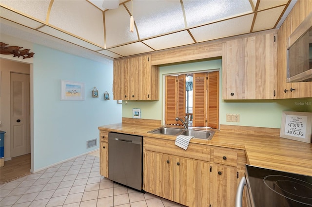 kitchen featuring appliances with stainless steel finishes, light brown cabinetry, sink, and light tile flooring