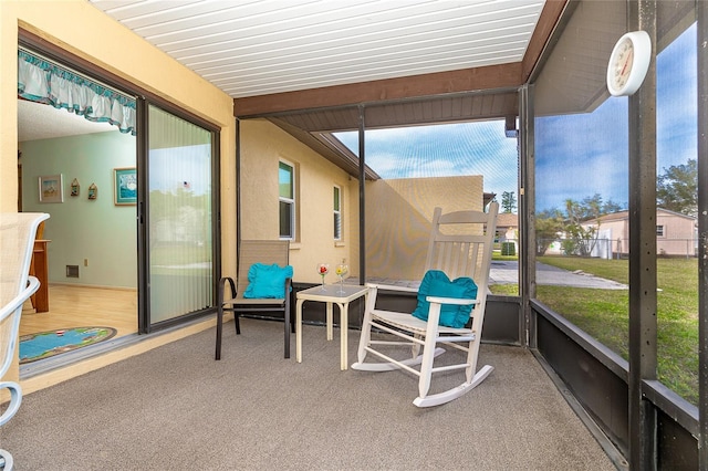 sunroom / solarium featuring beam ceiling