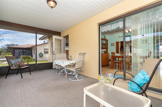 sunroom featuring beam ceiling