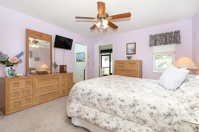 bedroom featuring light carpet, a textured ceiling, and ceiling fan