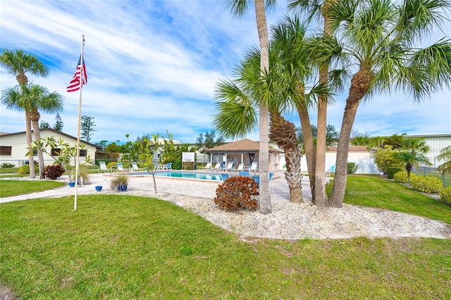 exterior space featuring a swimming pool and a yard