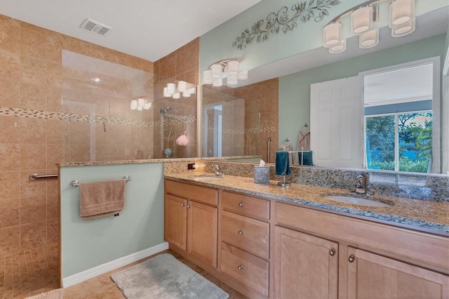 bathroom featuring a tile shower, tile floors, and dual bowl vanity