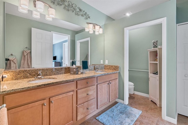 bathroom with double sink vanity, tile floors, and toilet