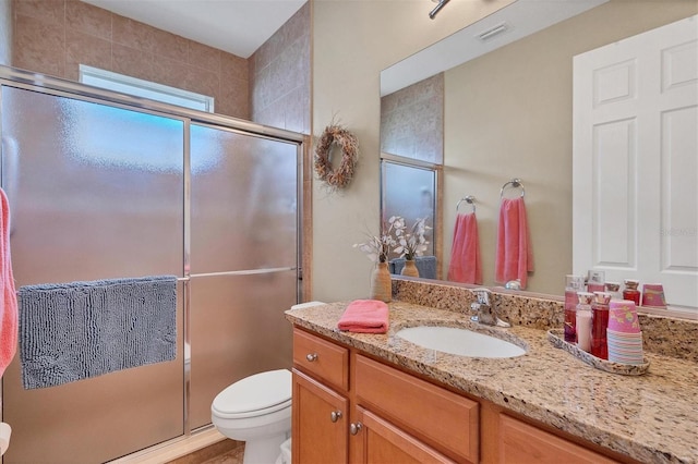 bathroom featuring an enclosed shower, vanity, and toilet