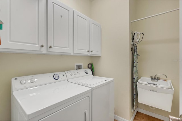 clothes washing area with washer and dryer, washer hookup, cabinets, and sink