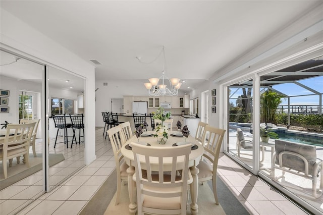 tiled dining room featuring a chandelier and a wealth of natural light