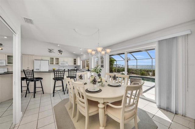 tiled dining space featuring ceiling fan and vaulted ceiling