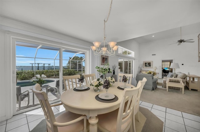 tiled dining room with plenty of natural light and ceiling fan with notable chandelier