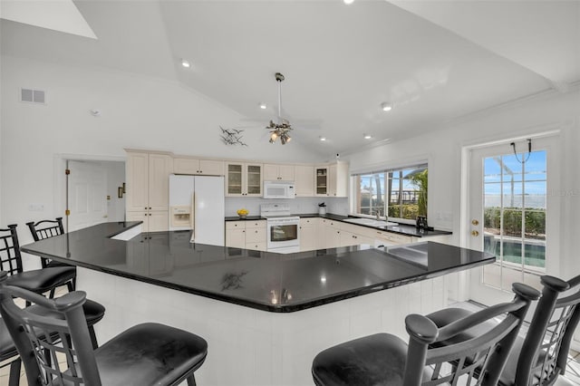 kitchen featuring vaulted ceiling, hanging light fixtures, a spacious island, and white appliances