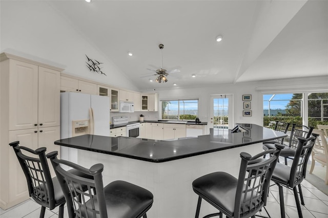 kitchen with ceiling fan, plenty of natural light, light tile patterned floors, and white appliances