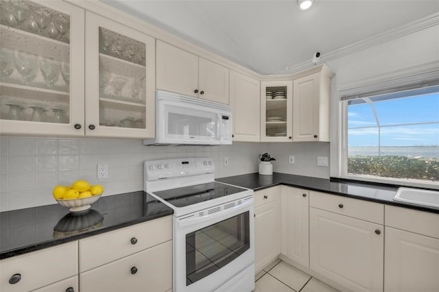 kitchen featuring backsplash, white cabinets, light tile patterned floors, and white appliances