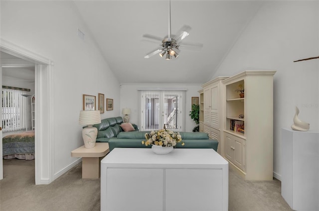 carpeted living room with ceiling fan and high vaulted ceiling