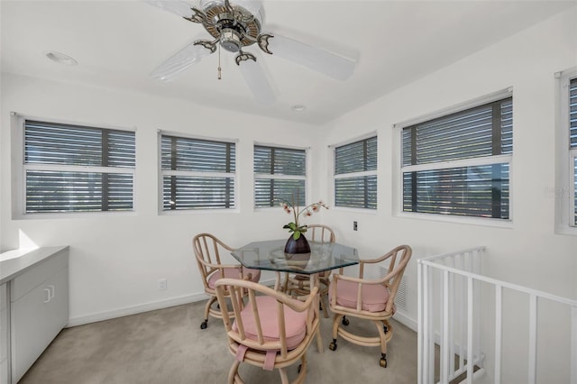 carpeted dining room with a wealth of natural light and ceiling fan