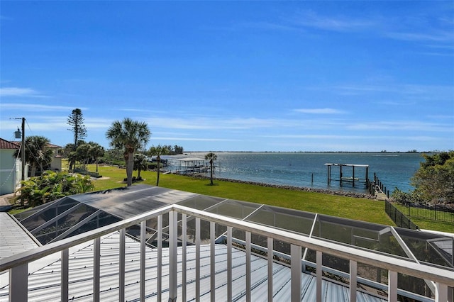 wooden terrace featuring a yard, a water view, and a boat dock