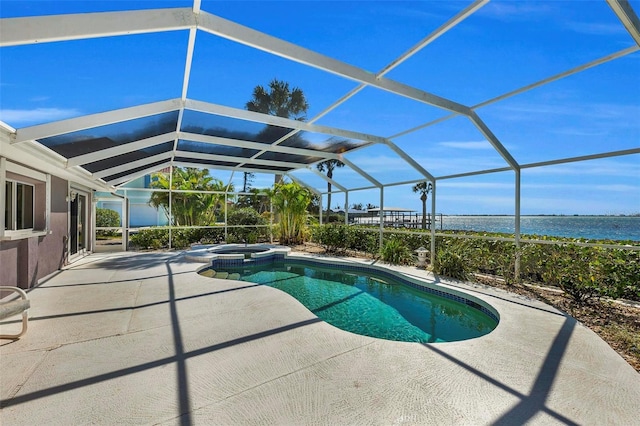 view of swimming pool with glass enclosure, an in ground hot tub, a patio area, and a water view