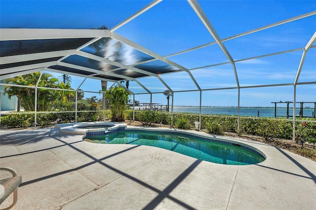 view of swimming pool with glass enclosure, an in ground hot tub, a patio area, and a water view