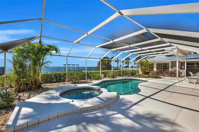 view of pool featuring glass enclosure, a water view, an in ground hot tub, and a patio