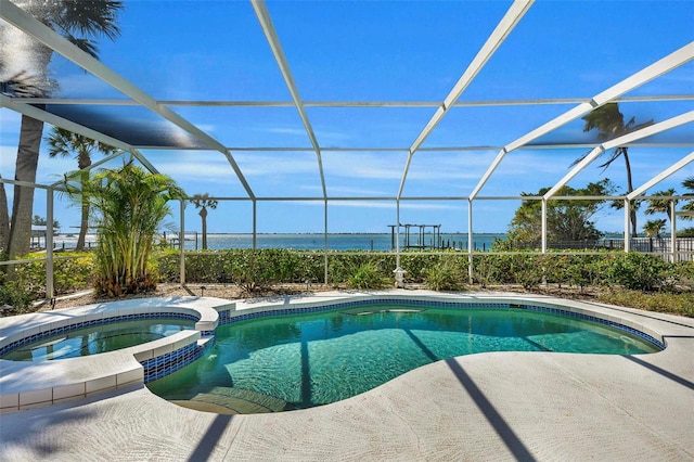 view of swimming pool with glass enclosure, an in ground hot tub, and a water view