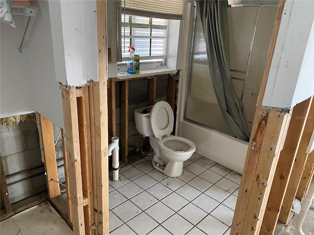 bathroom with tile patterned flooring, toilet, and shower / bath combination with glass door